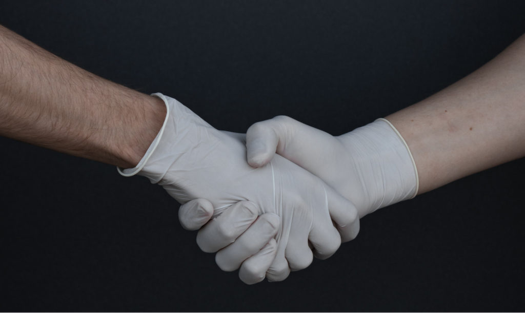 two hands holding with latex gloves