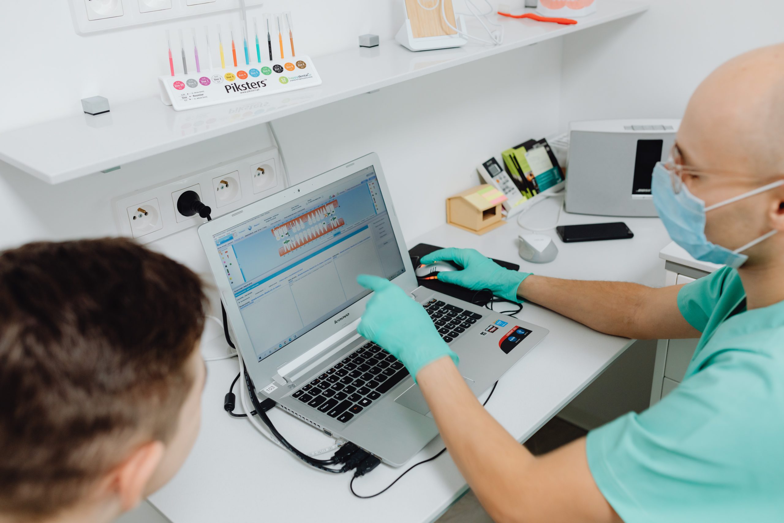 Dental staff member working with practice software on a laptop