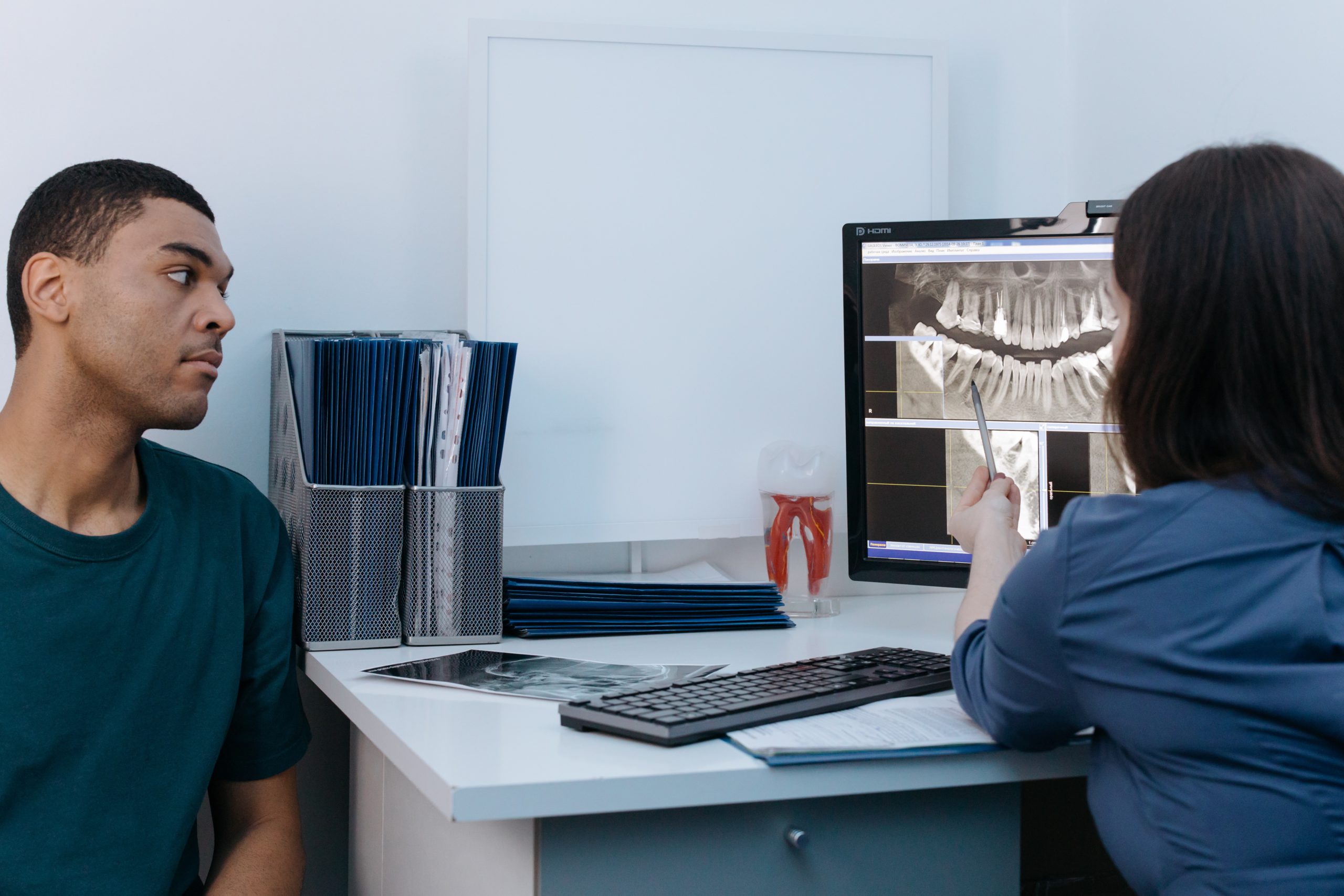 Two dental professionals reviewing an X-ray on a monitor
