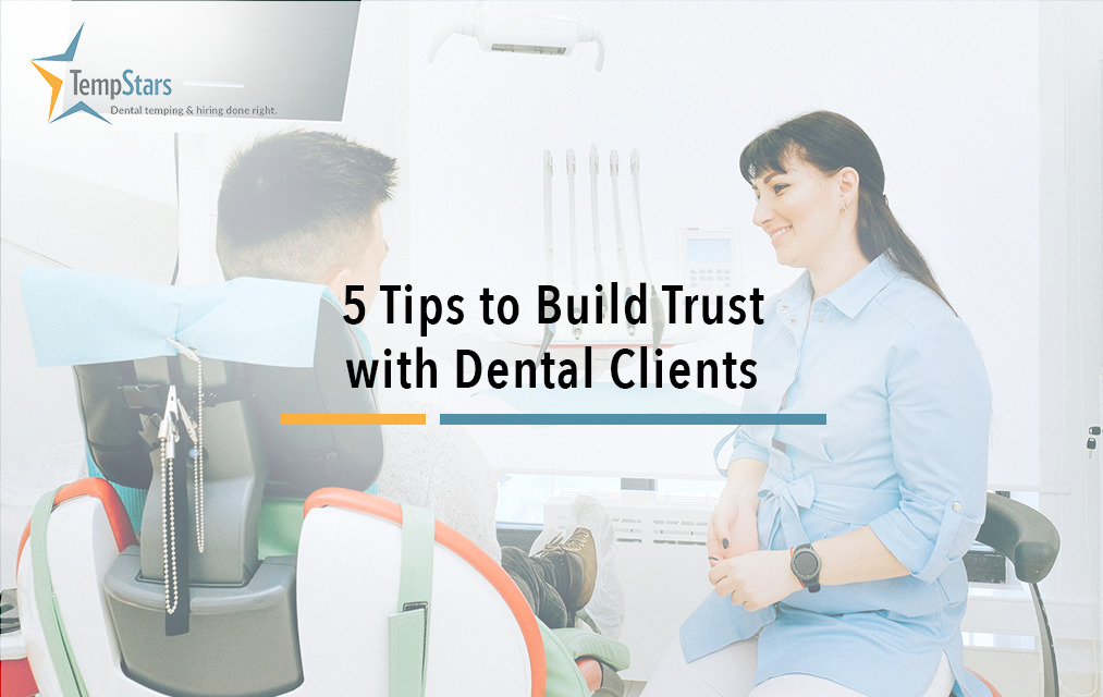 cheerful hygienist talking with patient sitting in dental chair
