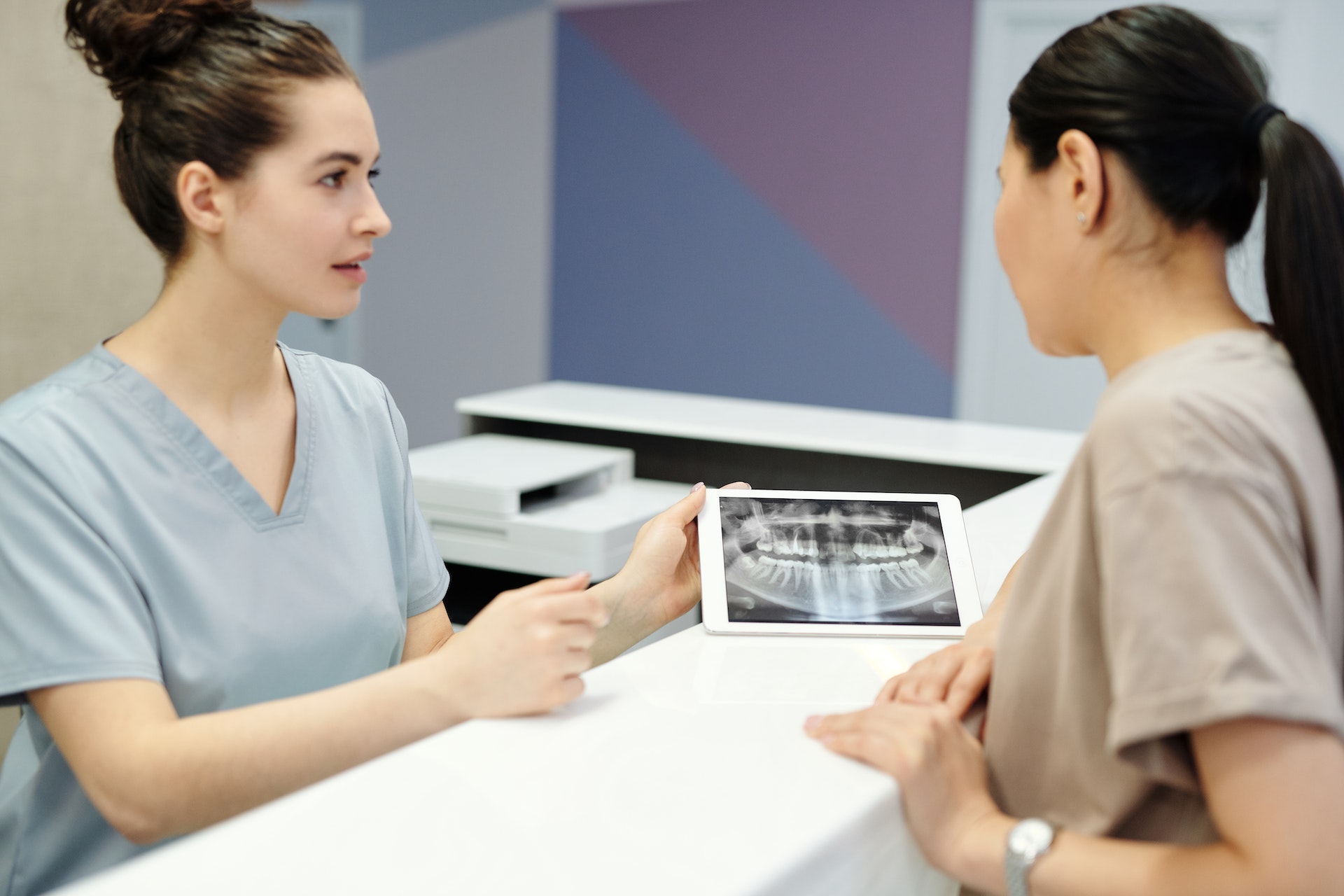 dental hygienist talking to another dental staff member showcasing clinical techniques