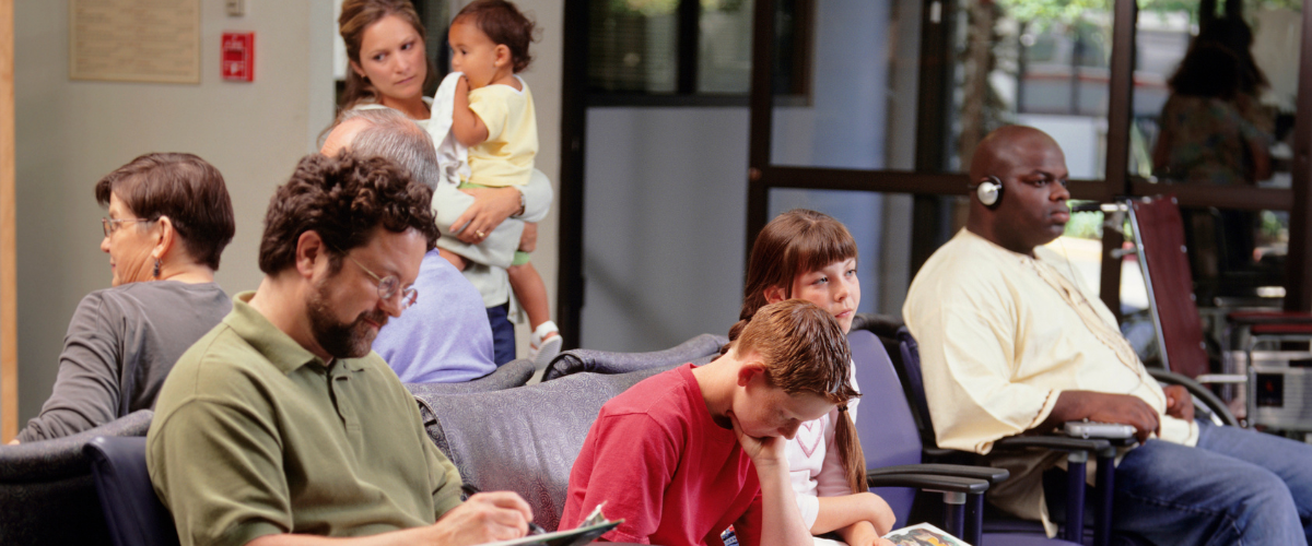 Patients waiting in a busy dental office waiting room.