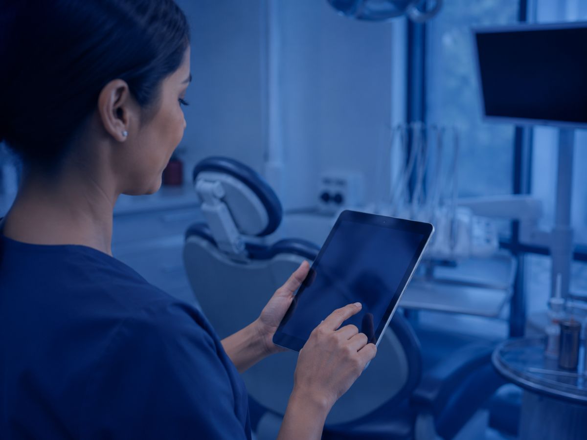 Dental professional reviewing a tablet in a modern operatory
